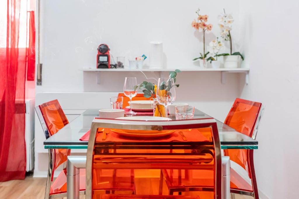 cocina con mesa y sillas de color naranja en Casa Golgi - Pavia City - by Host4U, en Pavia