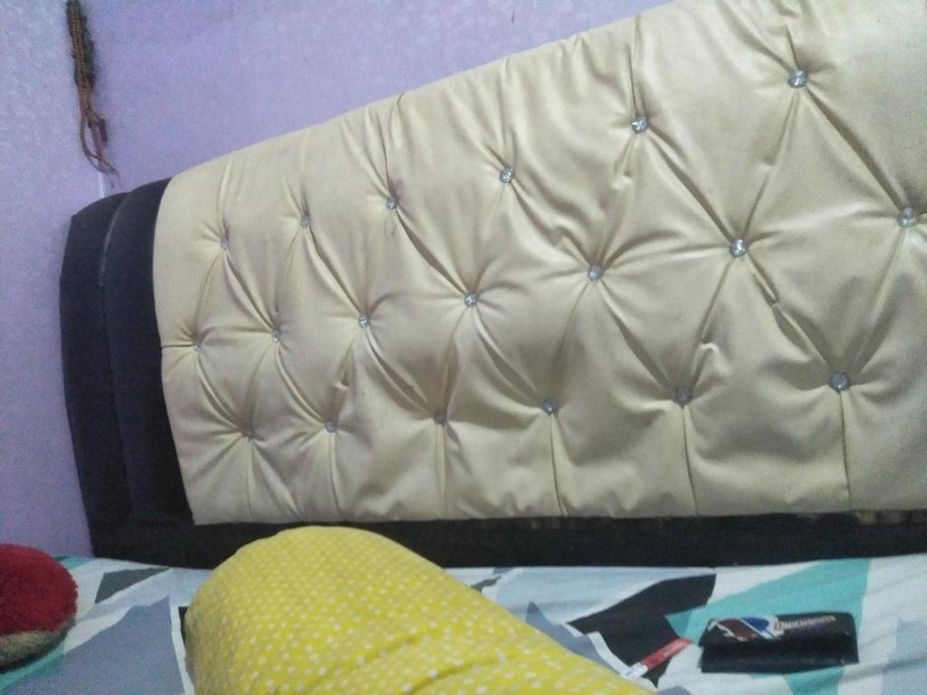 un sofá blanco en una esquina de una habitación en PondoK Bawah Duku, en Delitua
