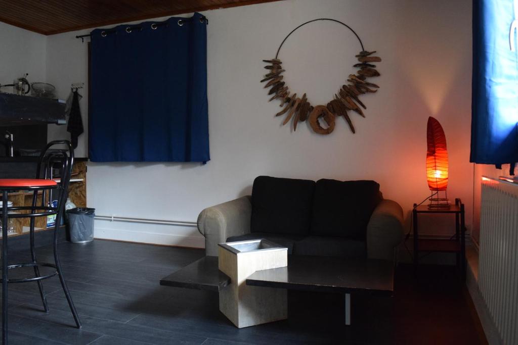 uma sala de estar com um sofá e uma mesa em Studio à la campagne proche du lac 