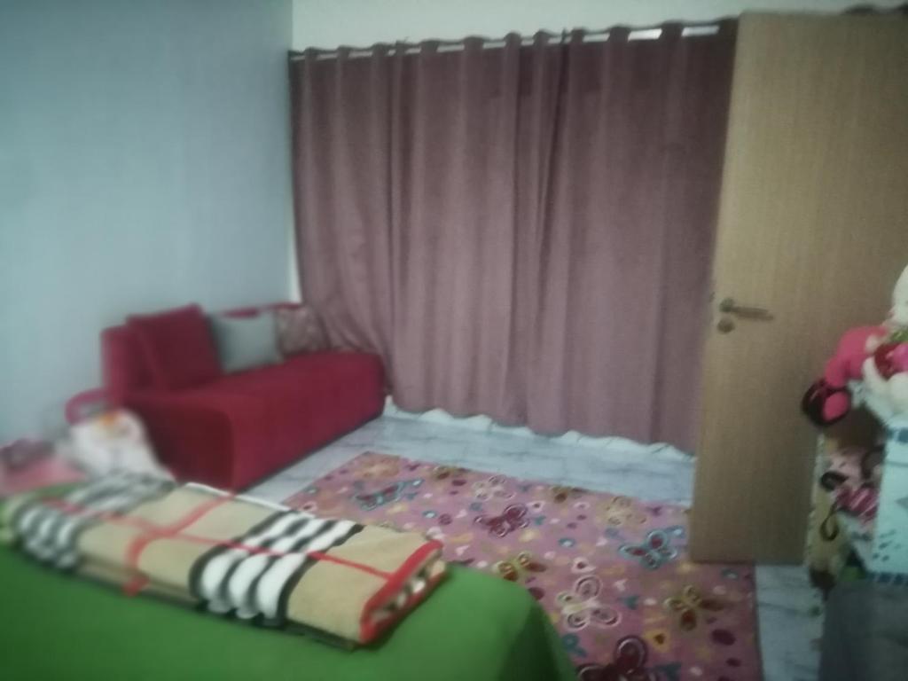 ein Wohnzimmer mit einem Sofa und einem roten Stuhl in der Unterkunft R&r in Skhirat