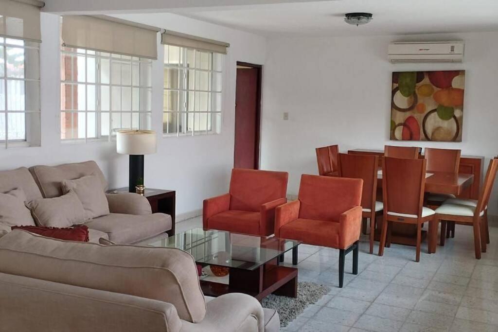 ein Wohnzimmer mit einem Sofa, einem Tisch und Stühlen in der Unterkunft La casa de Doña Emma in Lima del Alto