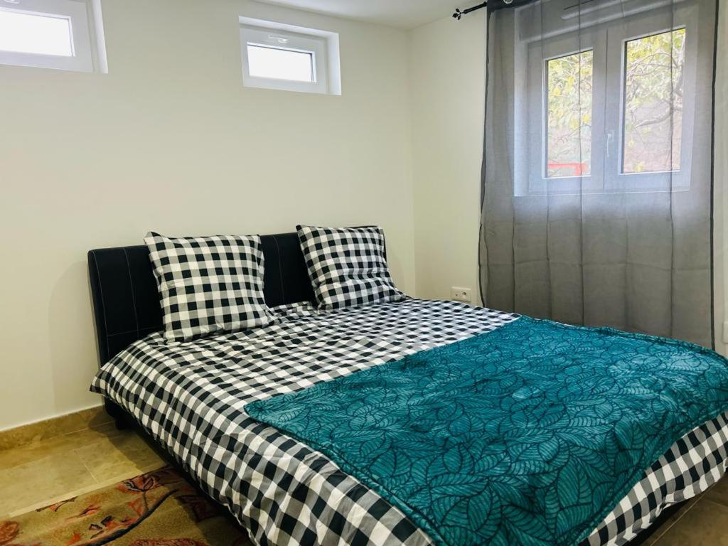 a bedroom with a bed with a checkered blanket at Petite Maison Proche aéroport Charles de Gaulles in Drancy