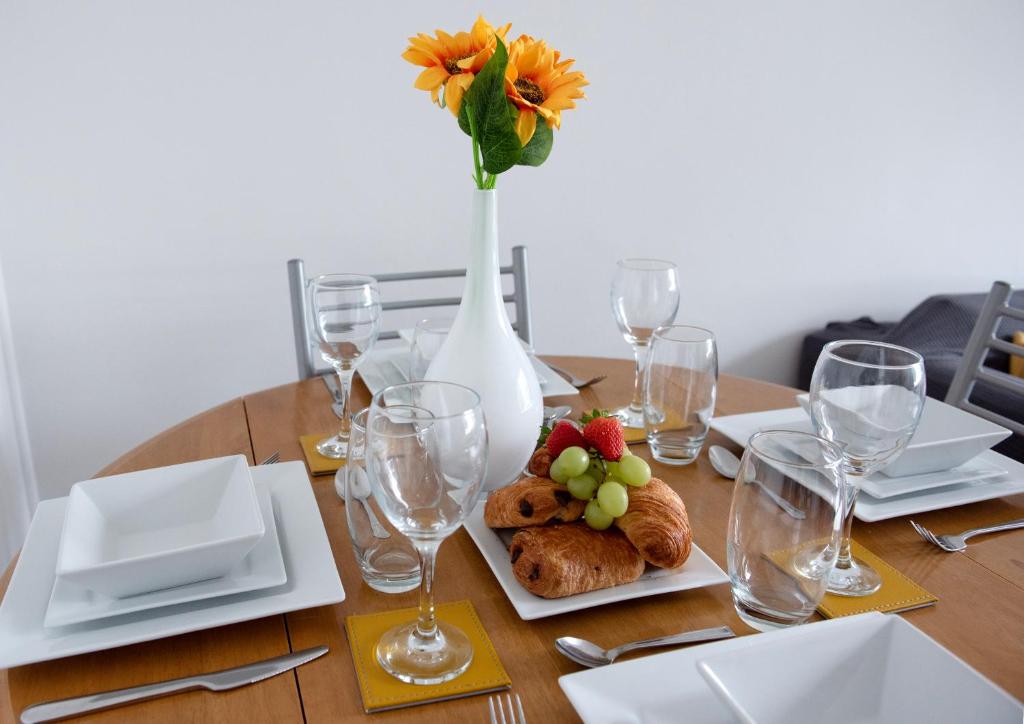 a table with a plate of food and a vase with a flower at Mowbray Quarters of Cambridge in Cambridge