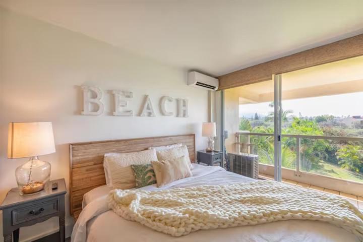 1 dormitorio con 1 cama con un cartel en la pared en Newly Renovated! Steps from Maui's Famous Beaches!, en Wailea