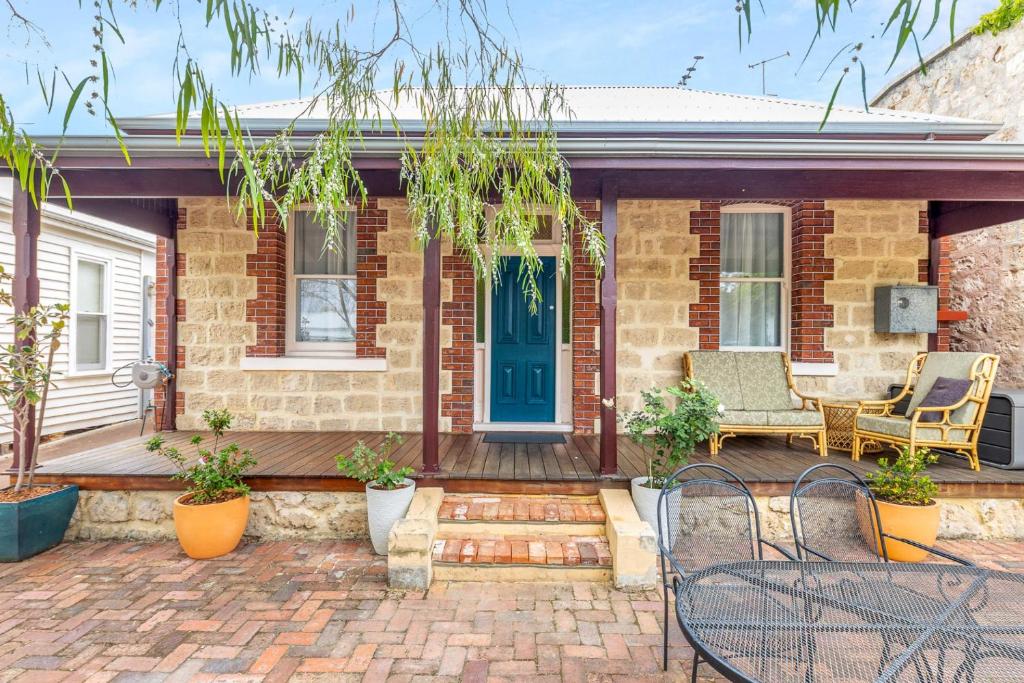 a brick house with a blue door and a patio at KING44 - King Charming in Fremantle