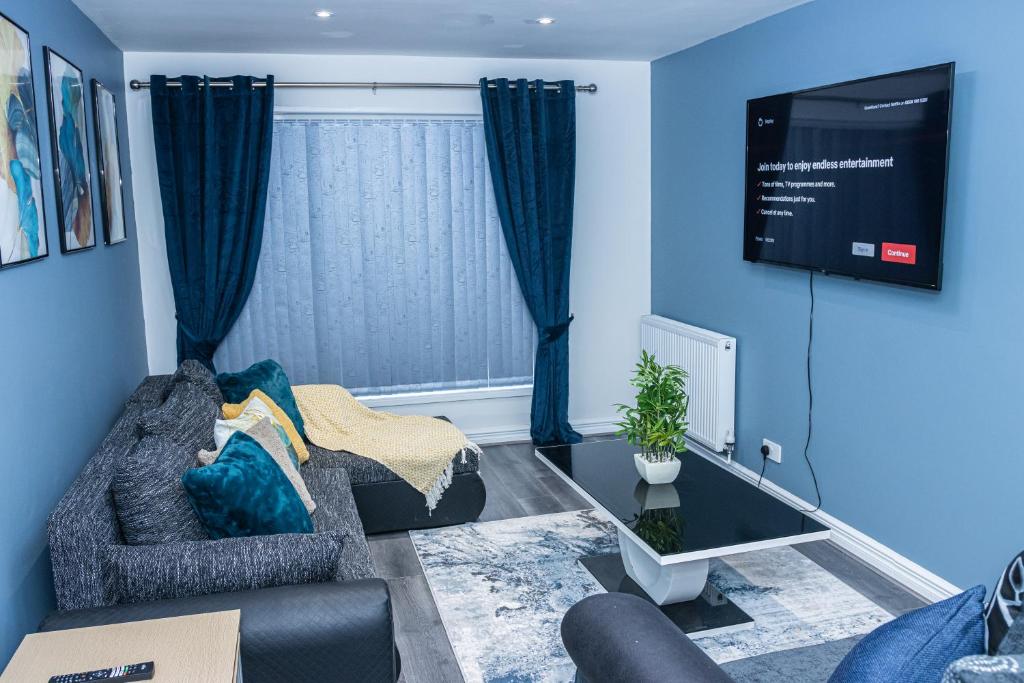 a living room with a couch and a tv at Lush Lodge -Home away in Telford in Telford