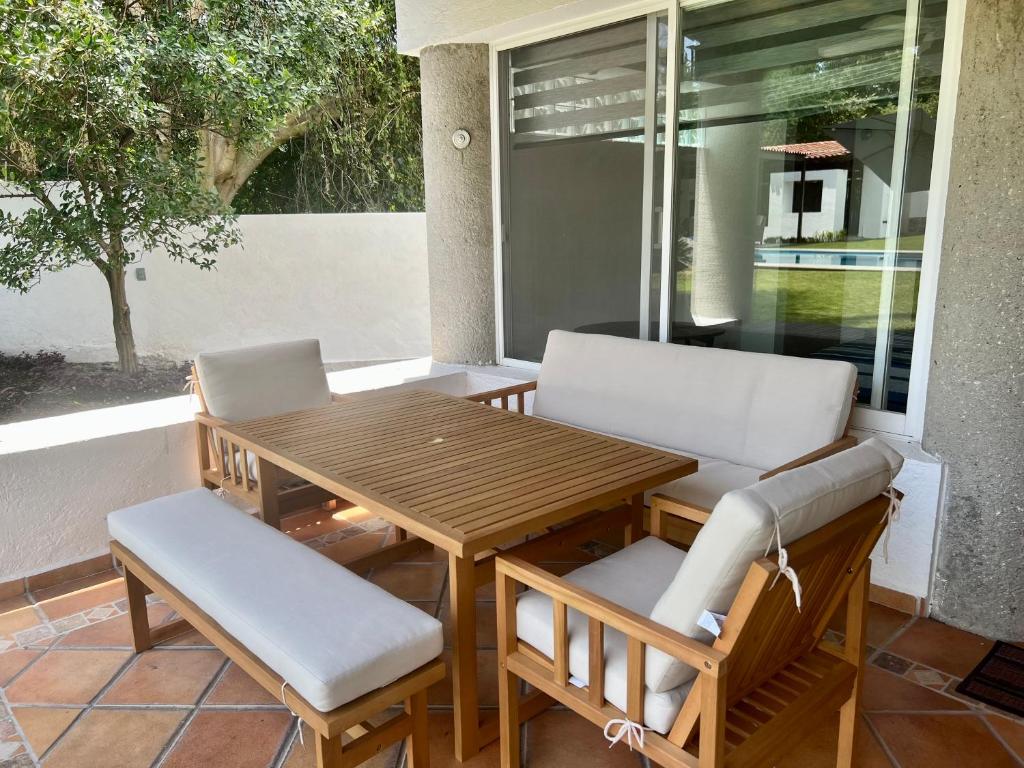 - une table et des chaises en bois sur une terrasse couverte dans l'établissement VILLA AMATE DORADO, à Xochitepec