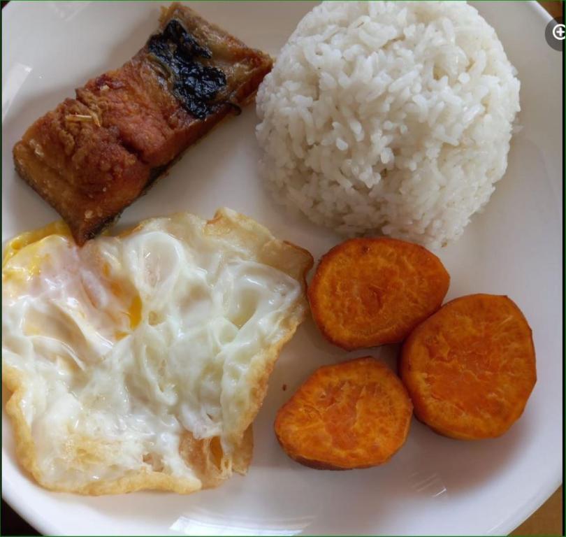een witte plaat met rijst en vlees bij 3rd and try travelers and pension house in Manilla