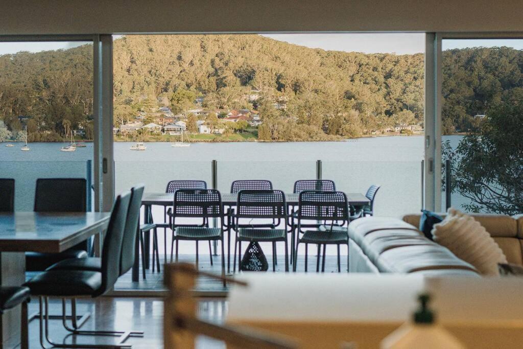 a room with a table and chairs and a large window at 11 East Gosford Luxury Waterfront House with Private Wharf in Gosford