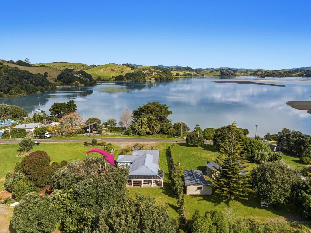 an aerial view of a house on the shore of a lake at Sandbach - Ohiwa Harbour in Waiotahi