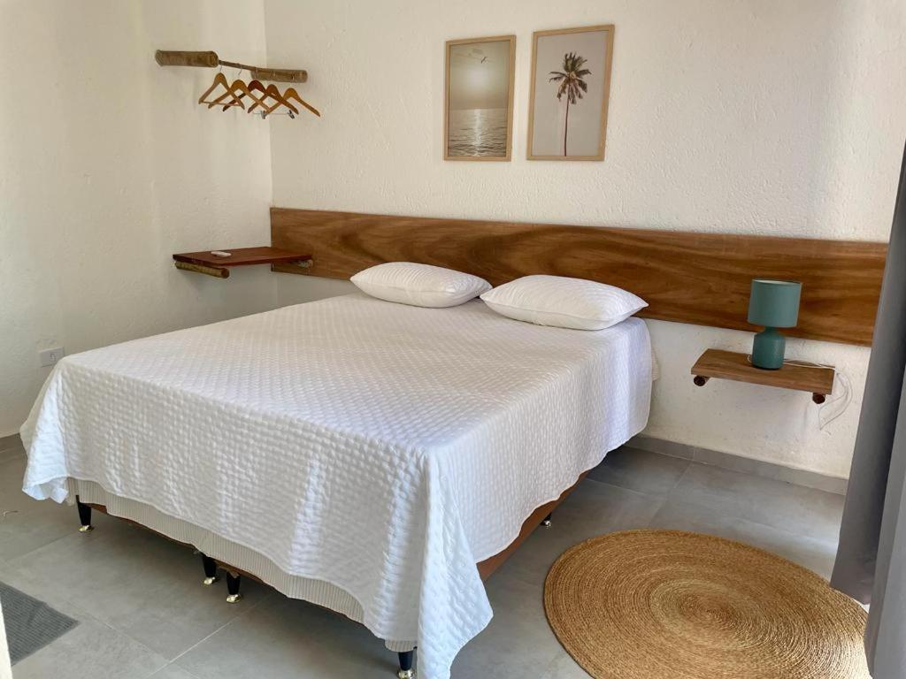 een slaapkamer met een bed met een witte deken bij Casa Nazar in São Miguel dos Milagres