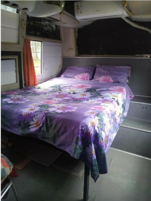 - un lit avec une couette violette dans l'établissement Mi bus, à Punta del Diablo