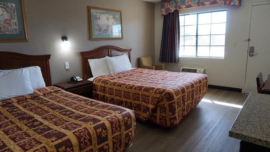 Habitación de hotel con 2 camas y ventana en Travel Inn Tucson, en Tucson
