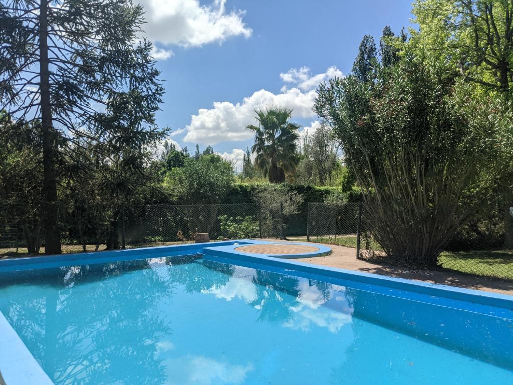 a blue swimming pool in a yard with trees at Quinta Don Benito - Chacras de Coria- in Ciudad Lujan de Cuyo