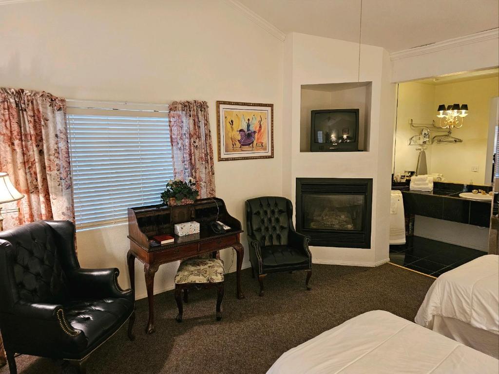 a room with a desk and chairs and a fireplace at Alhatti Christian Resort in Idyllwild