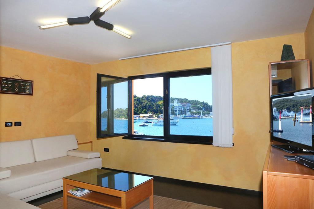 salon z kanapą i dużym oknem w obiekcie Apartments Ana City w Rovinj