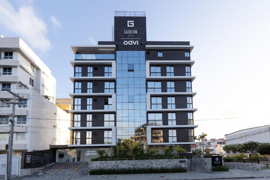 a tall building with a sign on top of it at Gaudium Apart-hotel por Quarto à Vista in João Pessoa