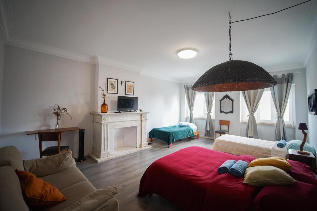 a living room with a bed and a couch at Aquarela do Tejo Guesthouse in Vila Franca de Xira