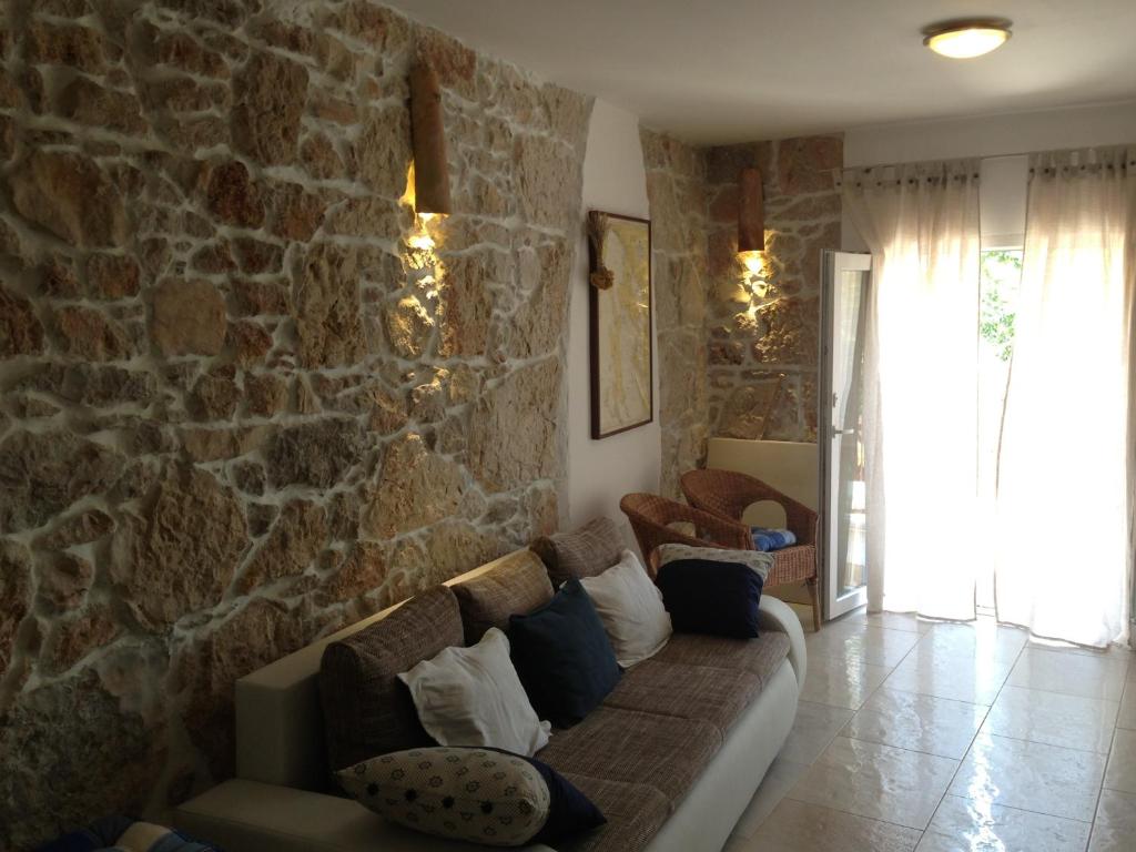 a living room with a couch and a stone wall at TEN-Punat Apartments in Punat