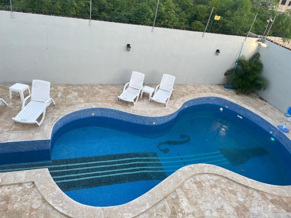 uma piscina com duas espreguiçadeiras e uma piscina em Villa Gordon em Santa Cruz de Barahona