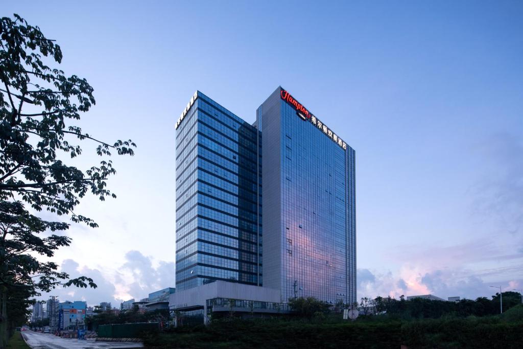 un grand bâtiment avec un panneau sur celui-ci dans l'établissement Hilton by Hampton Guangzhou Xintang, à Zengcheng