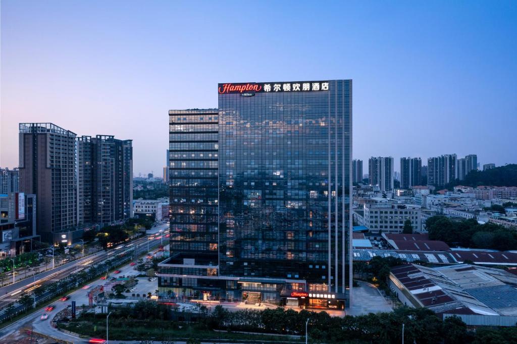 ZengchengにあるHilton by Hampton Guangzhou Xintangの市の看板が貼られた高層ビル