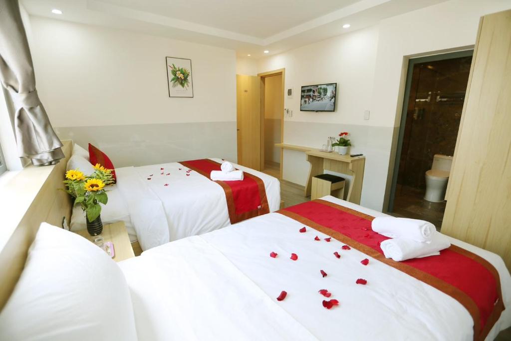 una camera d'albergo con due letti con rose sopra di Song Thiện Homestay a Hoi An