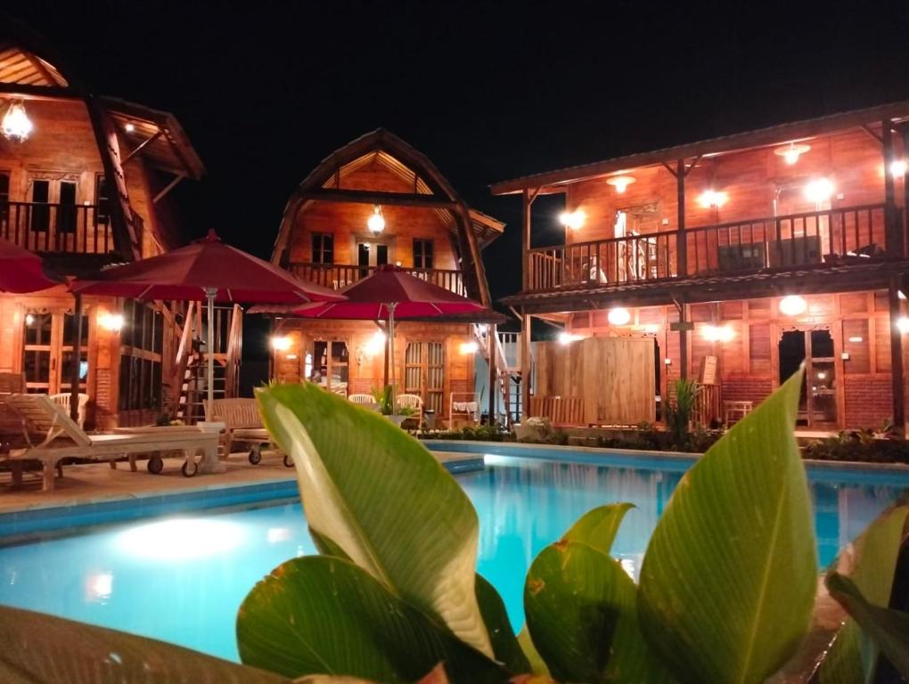 a resort with a swimming pool at night at Melasti Mountain Villas, Amed, Room 3 Agung Guesthouse in Amed
