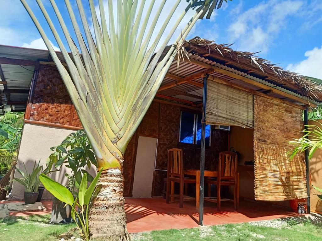 une maison avec une table, des chaises et un palmier dans l'établissement Panglao Vacation Home, à Panglao