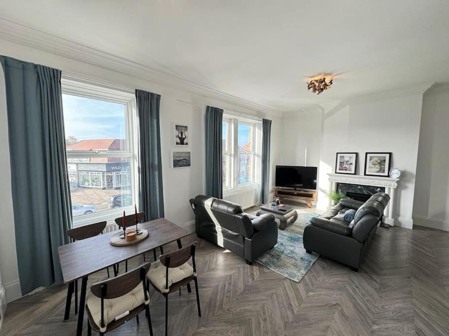 a living room with a couch and a table and chairs at Longsands Apartment, Tynemouth Luxury Coastal Retreat in Tynemouth