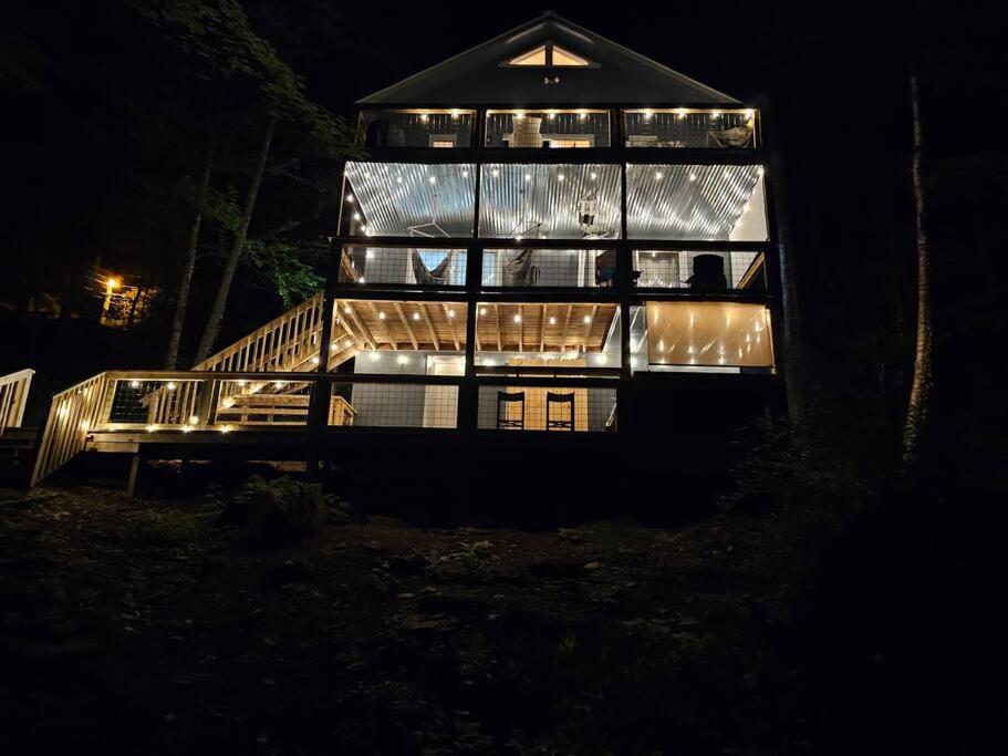 Una casa de noche con luces encendidas. en Cozy Mountain Chalet With Hot Tub Outdoor Movie Screen And Fire Place, en Banner Elk