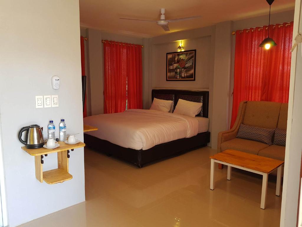 a bedroom with a bed and a chair at CHEAGIA Resort at Sitinjo near Sidikalang in Hutamanik