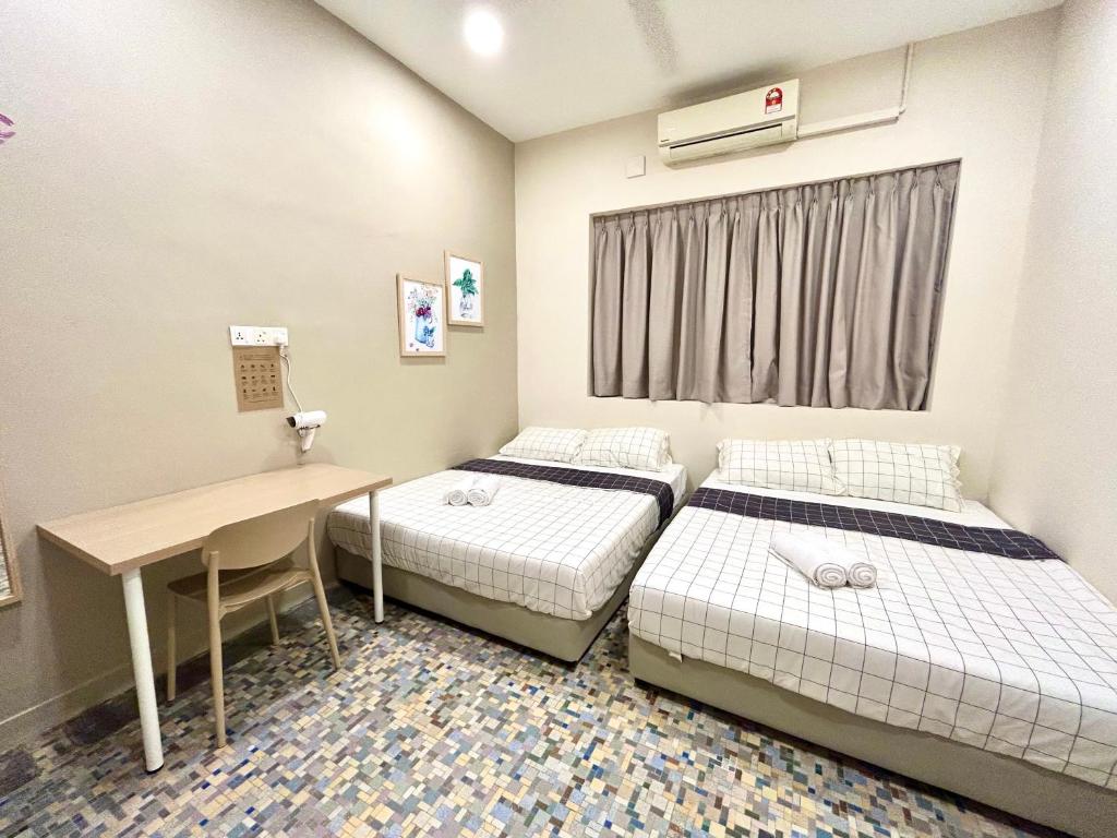 a room with two beds and a desk in it at myROOM @ Mandalay Georgetown, Off Jln Burma, Gurney Drive in George Town