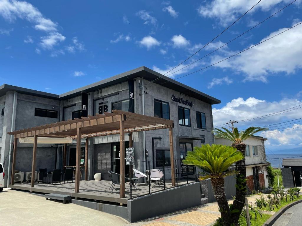 a house with a large deck in front of it at Book Tea Bed IZUOSHIMA in Oshima