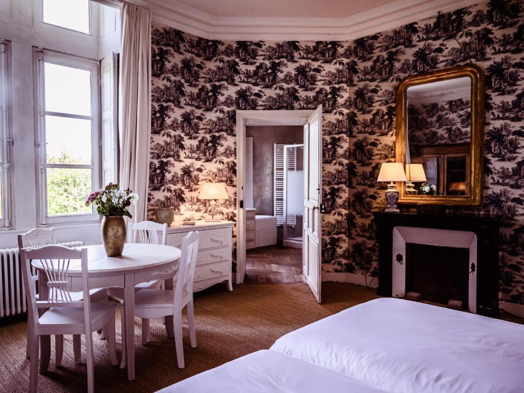 sypialnia z łóżkiem, stołem i lustrem w obiekcie Grand Château Renaissance avec Parc, Piscine et Activités, Rénové en 2023 - FR-1-410-389 w mieście Vallon-sur-Gée