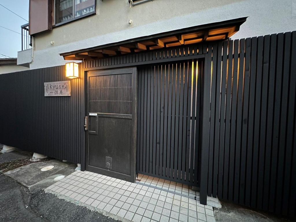 une clôture noire avec une porte et un bâtiment dans l'établissement Numazu Japanese house / Vacation STAY 3966, à Numazu