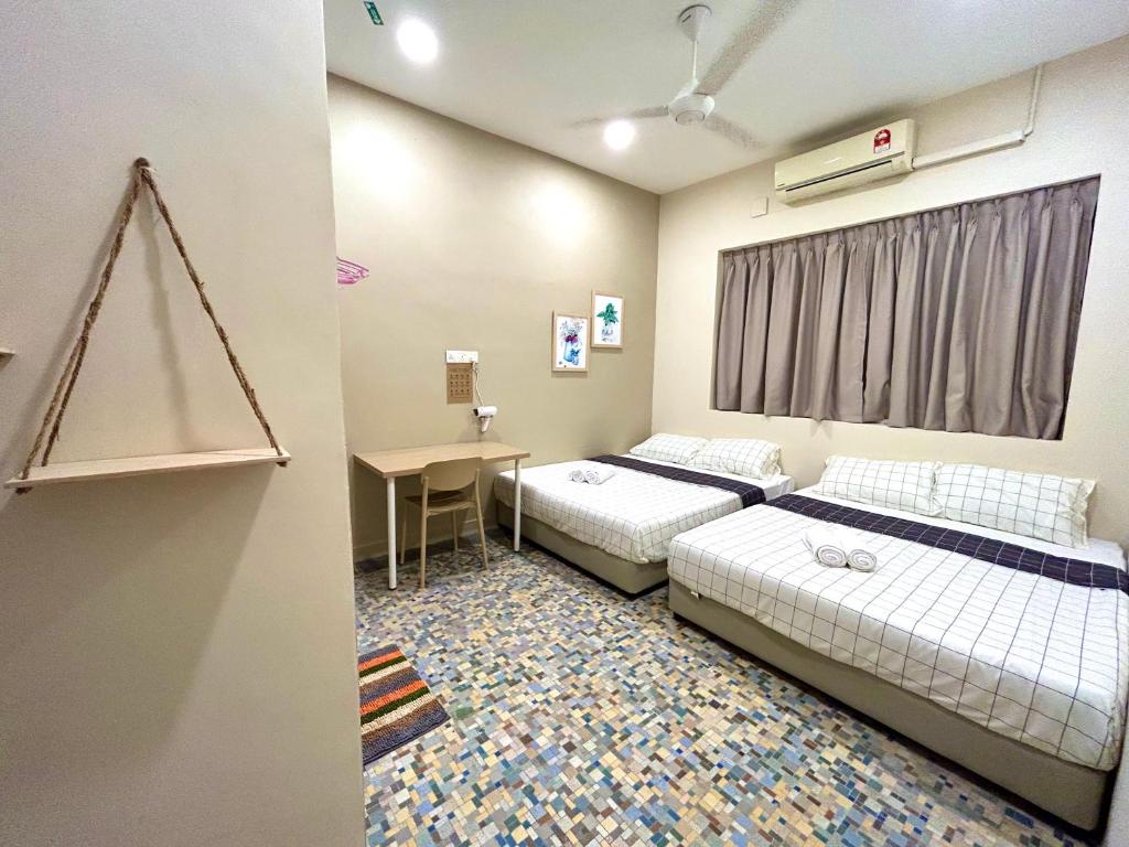 two beds in a room with a table and a desk at myROOM @ Mandalay Georgetown, Off Jln Burma, Gurney Drive in George Town