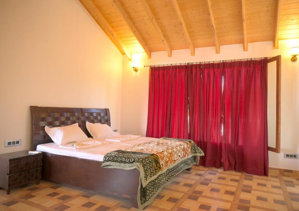 um quarto com uma cama com uma cortina vermelha em Camp Banas Naudhiya em Budia