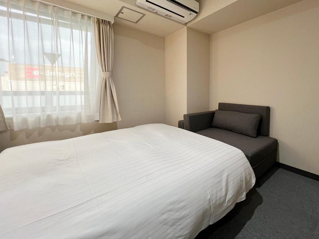 Postel nebo postele na pokoji v ubytování CHECKinn Osaka Shinimamiya
