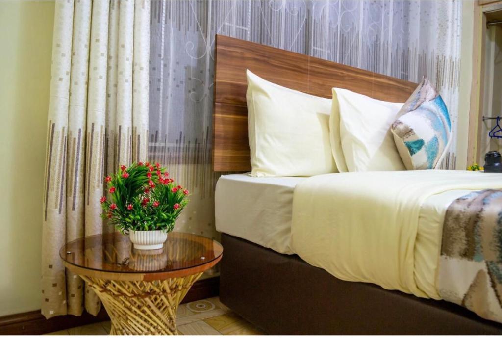 Postel nebo postele na pokoji v ubytování RAiNBOW APARTMENTS NYARUTARAMA
