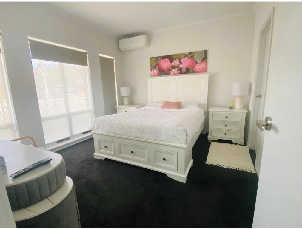 a bedroom with a white bed and a window at Modern Private room with ensuite in Smithfield