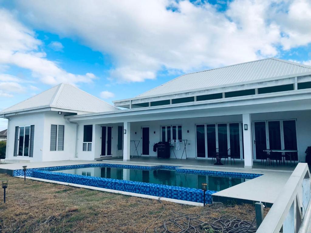 a house with a swimming pool in front of it at Lake Side Villa Naisoso in Nadi