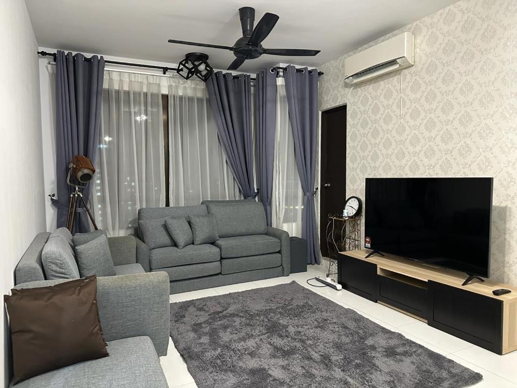uma sala de estar com um sofá e uma televisão de ecrã plano em The Heights Residence Condo Ayer Keroh Melaka WIFI 100mbps em Ayer Keroh