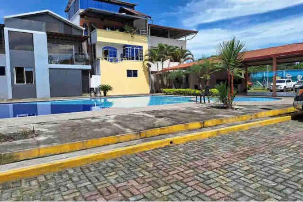 a swimming pool in front of a house at departamento con piscina y áreas sociales in Santo Domingo de los Colorados