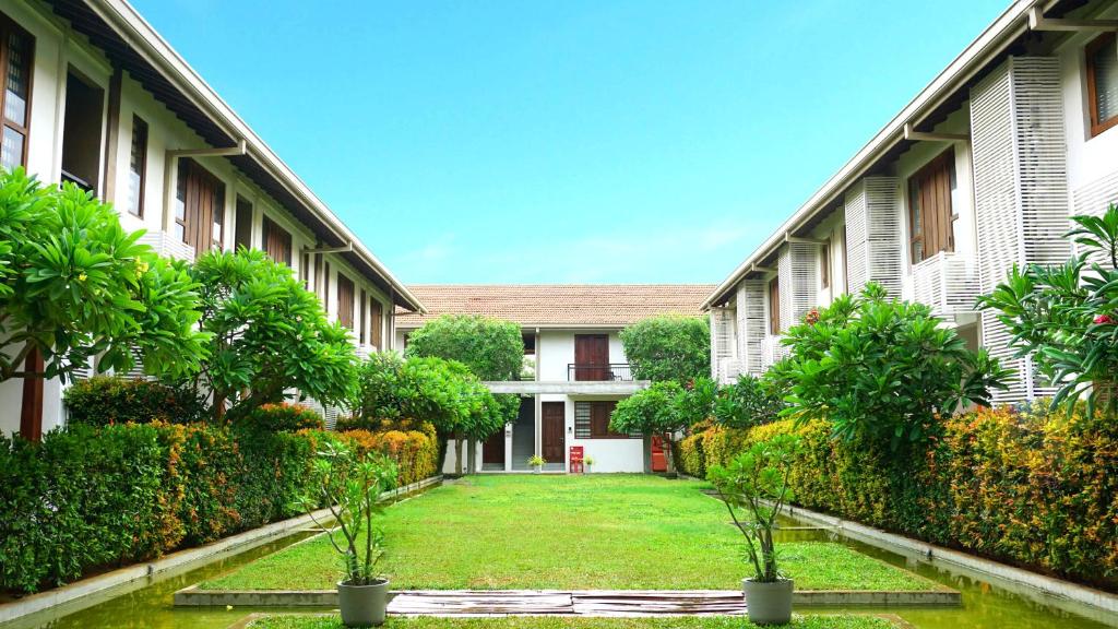 une cour d'un bâtiment avec des arbres et des plantes dans l'établissement The Thinnai - All-Suites Boutique Hotel, à Jaffna