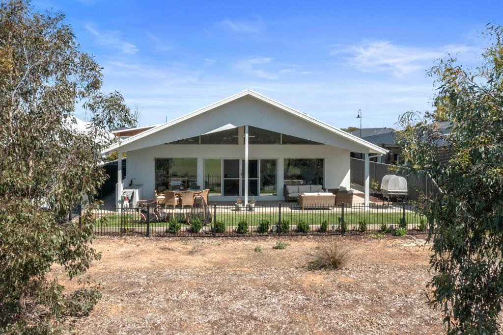 una casa blanca con una valla delante en Golf Fronted on the 6th Fairway, en Yarrawonga