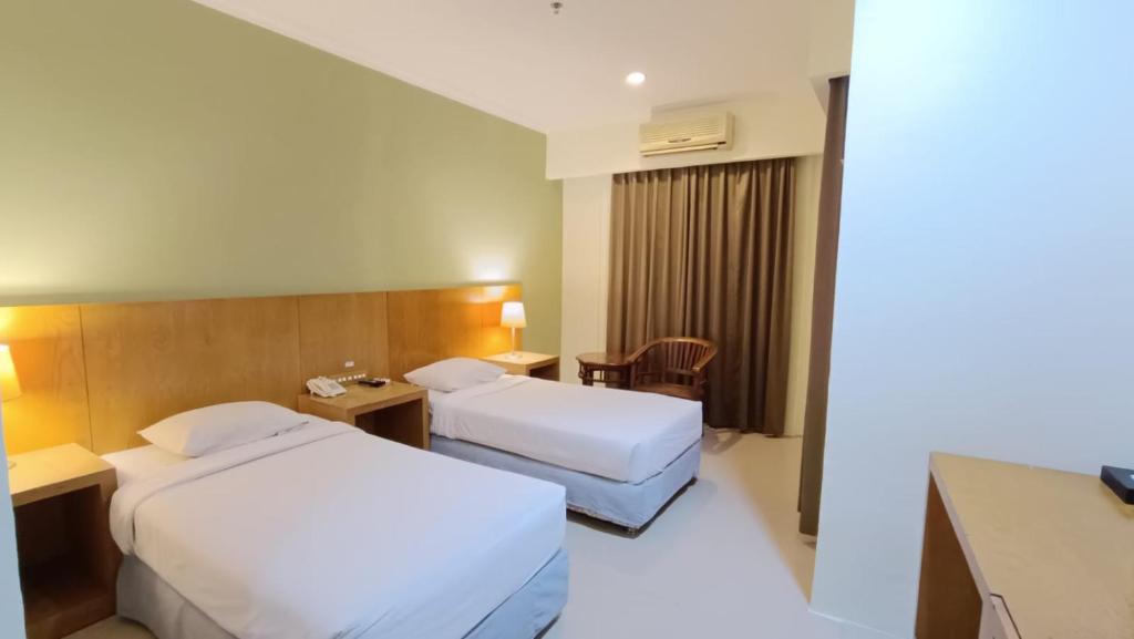 Postel nebo postele na pokoji v ubytování Hotel Wisata