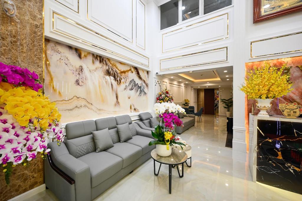 a lobby with a couch and flowers on the wall at Vivian Airport Hotel Saigon in Ho Chi Minh City