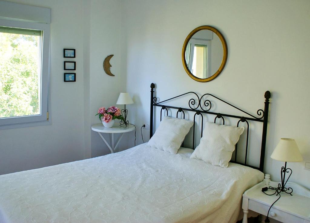Villa Javea في خافيا: غرفة نوم بسرير كبير ومرآة على الحائط