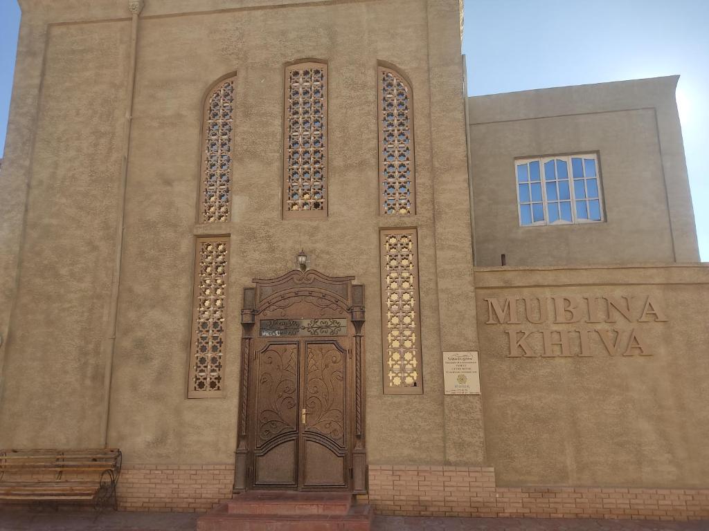 een kerk met een grote houten deur op een gebouw bij Mubina Khiva B&B in Khiva